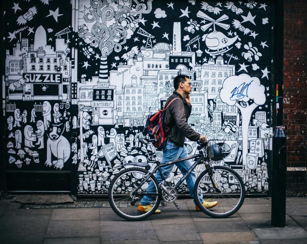 Man in black talking on phone while cycling